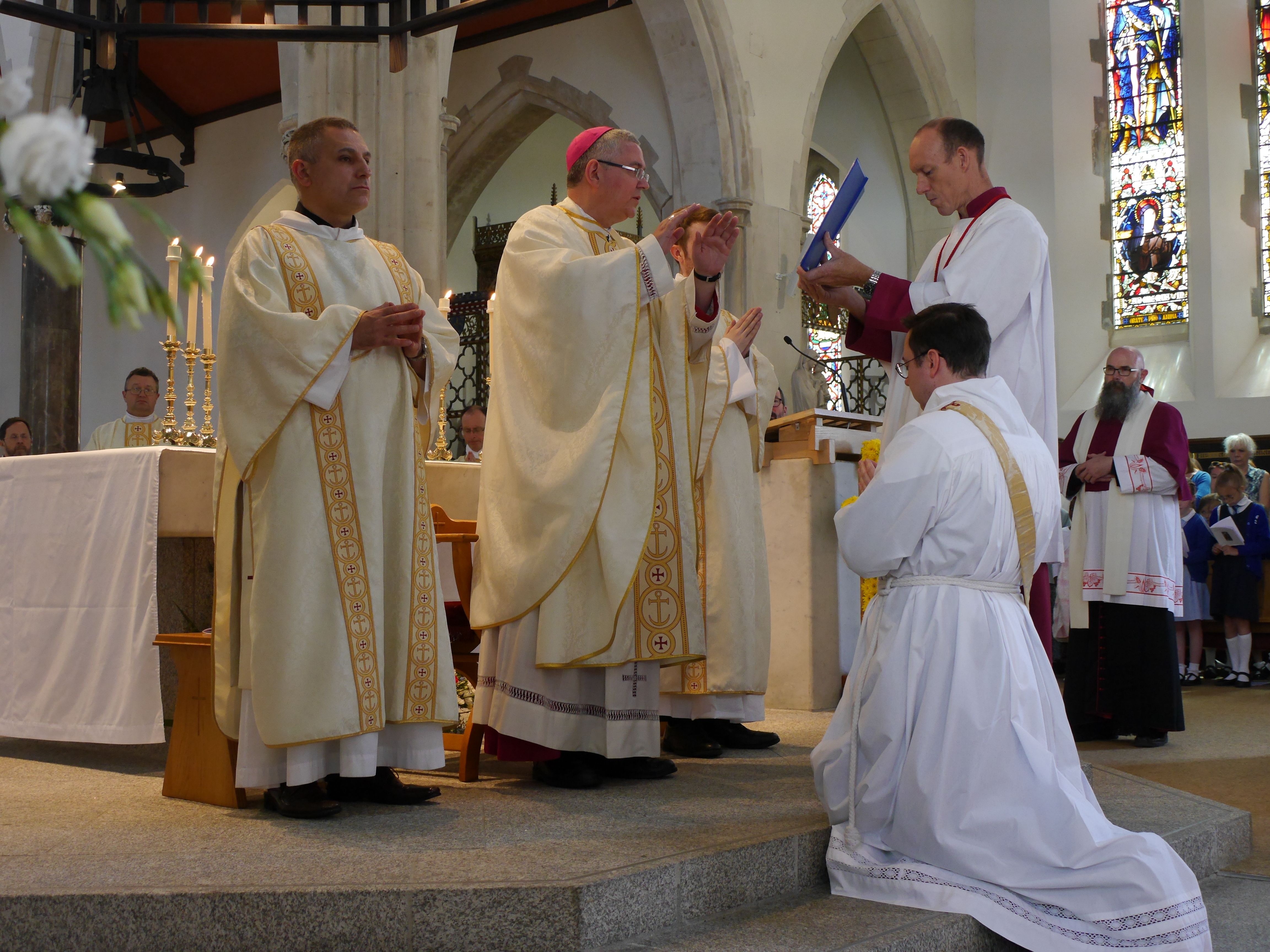 Deacon James first kneels before the bishop as he pledges his “Promise of Obedience.”