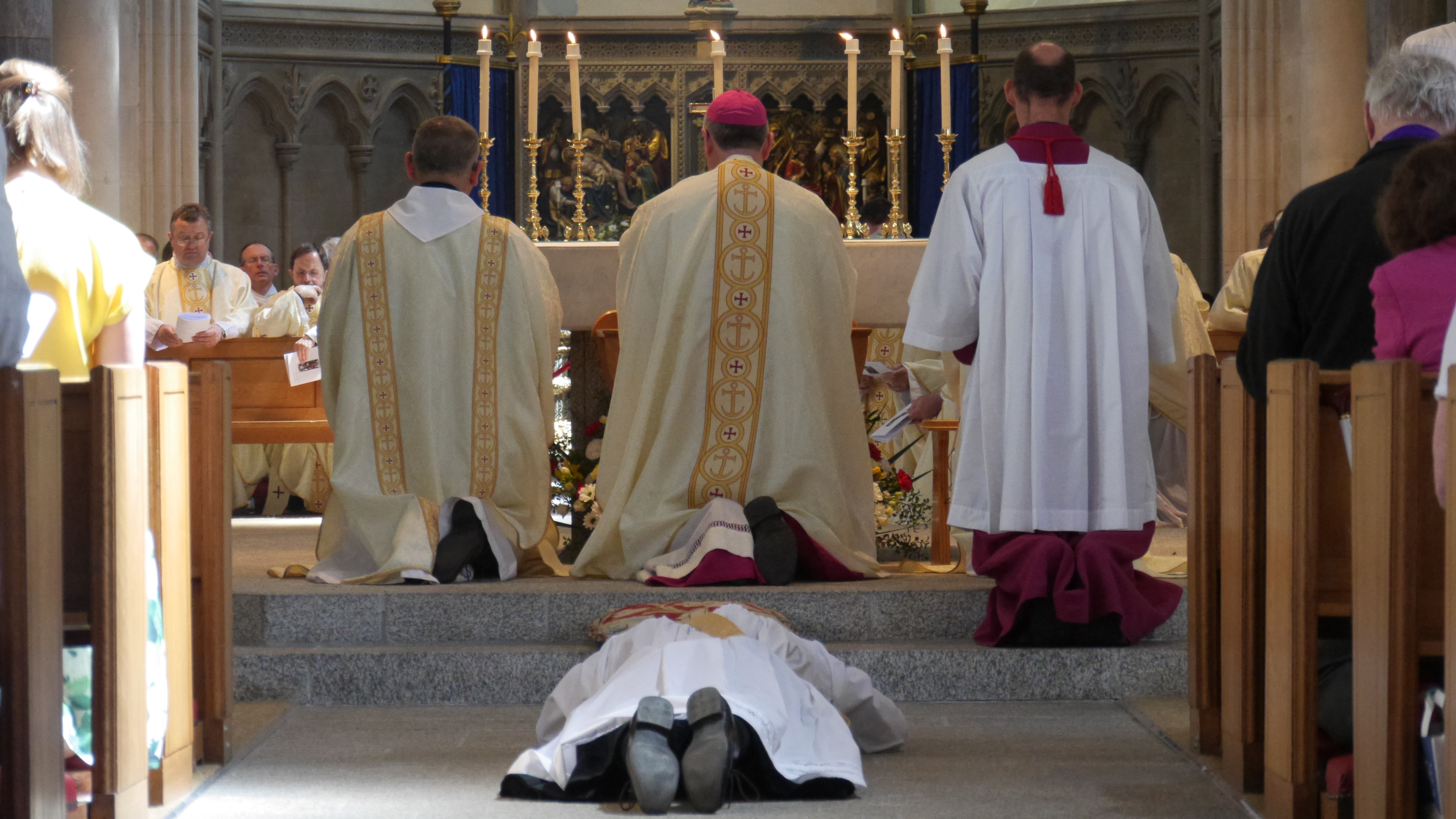 Deacon James lies prostrate on the floor while the bishop, priests, and parishioners recite the Litany of Saints